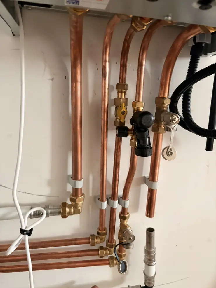 New copper pipework with isolation valves under a boiler