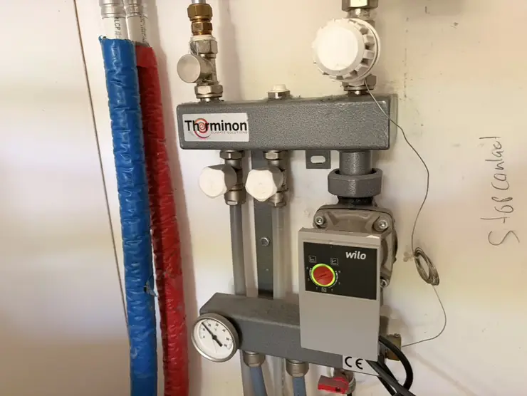An underfloor heating pump group with insulated flow and return pipes